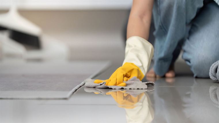 Cleaning a tiled floor by hand during a deep clean