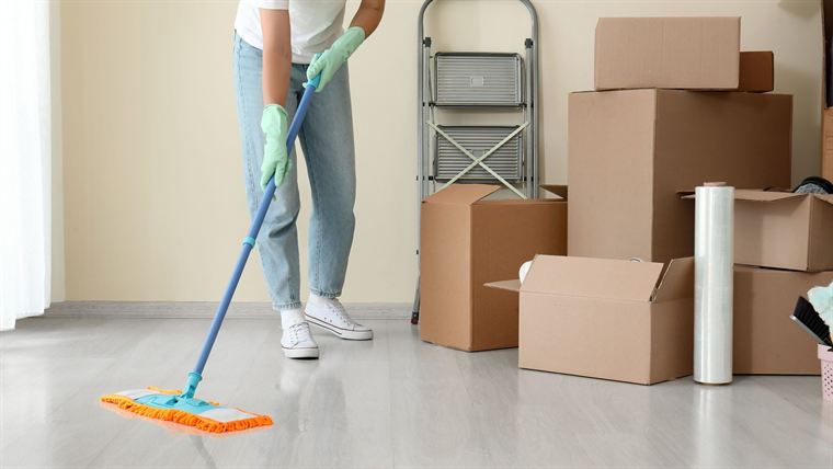 Mopping an empty room surrounded by moving boxes